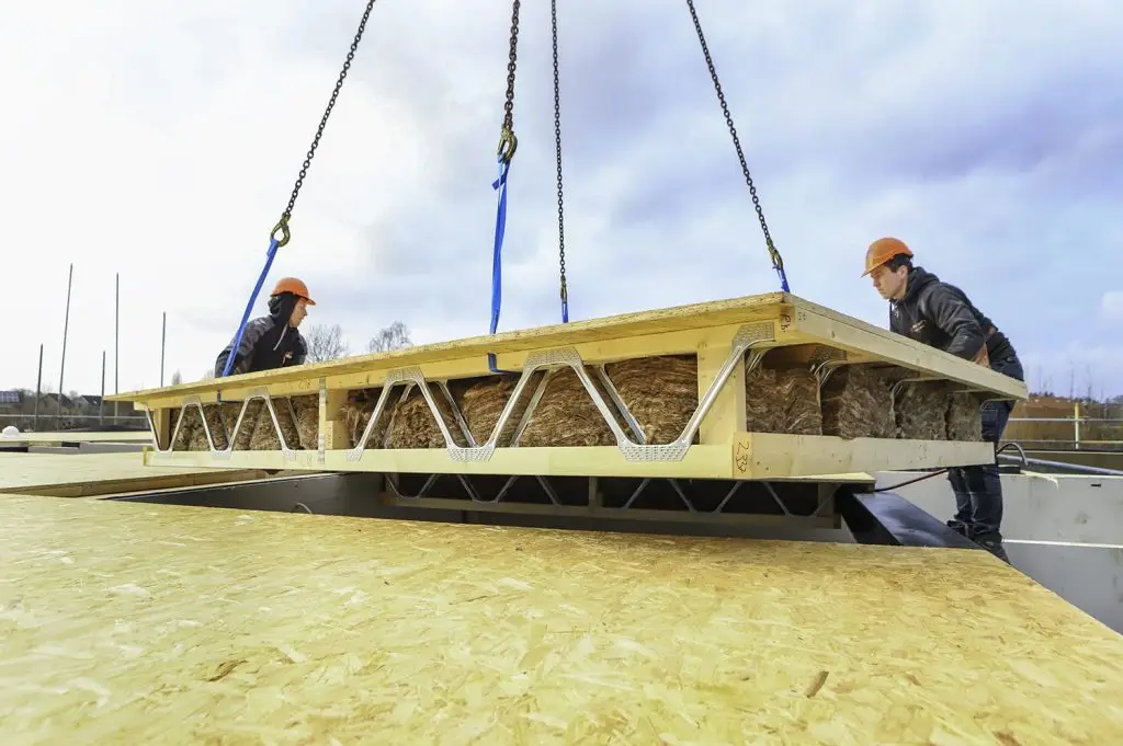 Prefab Posi-Joist vloercassette wordt door 2 monteurs gehesen op de bouwplaats in Leersum